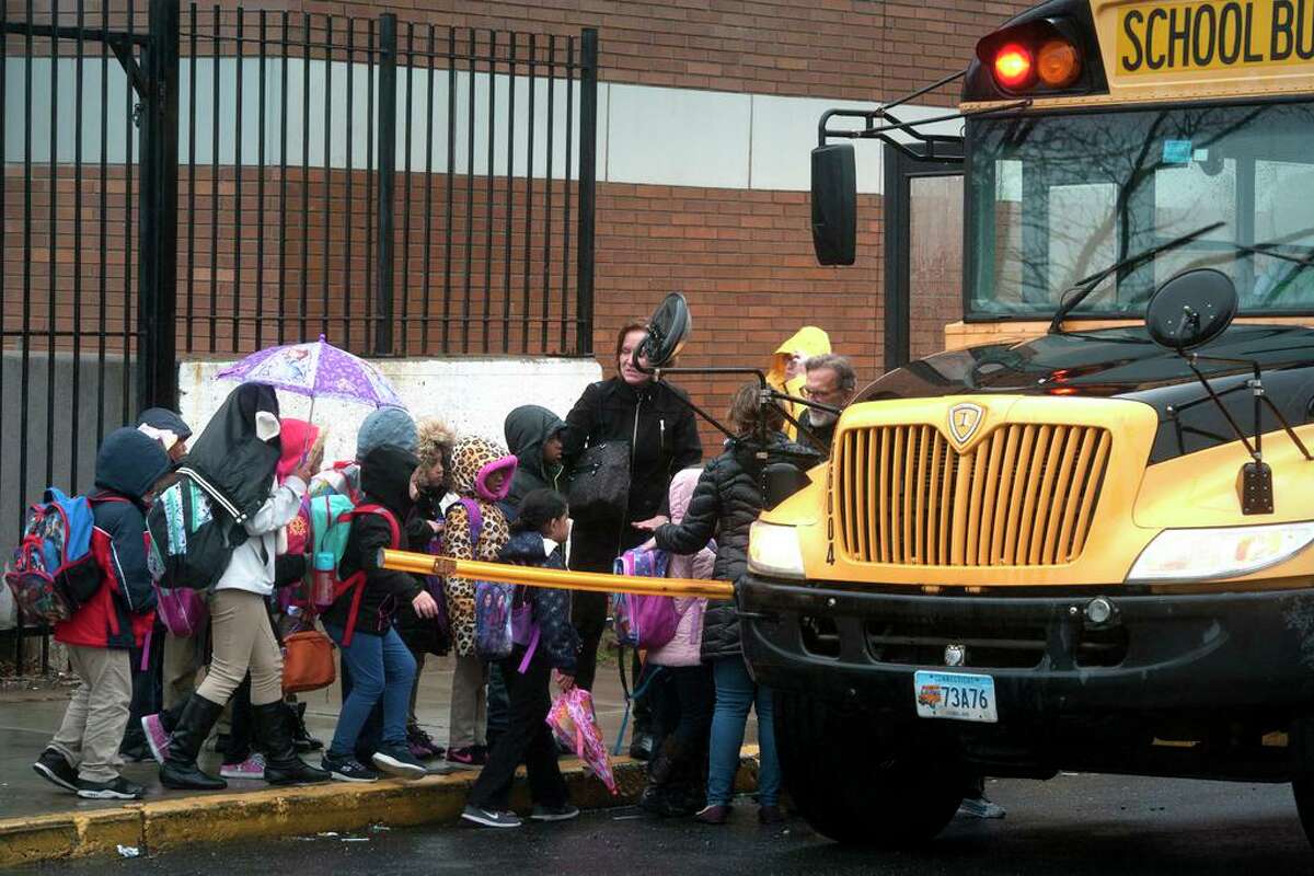 Students board buses at Columbus School after it was evacuated when an unusual odor was detected in Bridgeport, Conn. April 6, 2017.