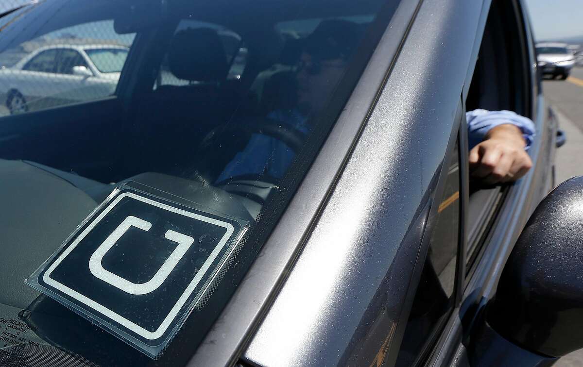 Uber driver Karim Amrani sits in his car parked near the San Francisco International Airport parking area in San Francisco, Wednesday, July 15, 2015. In the three months ended in June, Uber overtook taxis as the most expensed form of ground transportation, according to expense management system provider Certify. (AP Photo/Jeff Chiu)