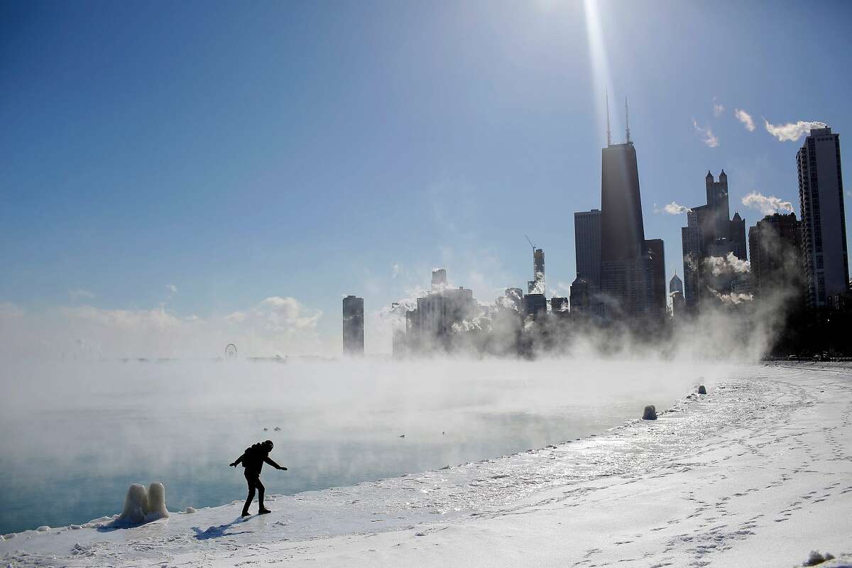 Marius Radoi keeps his balance as he walks on the edge of Lake Michigan's shore line as temperatures dropped to -20 degrees F (-29C) on January 30, 2019 in Chicago, Illinois. - Frostbite warnings were issued for parts of the US Midwest on January 30, 2019, as temperatures colder than Antarctica grounded flights, forced schools and businesses to close and disrupted life for tens of millions. 
