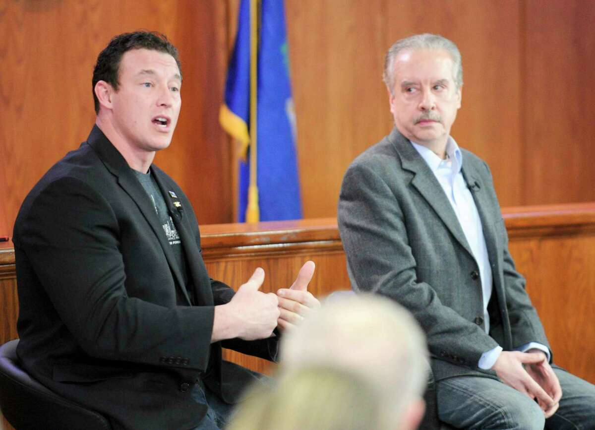 Tom Borelli, at right, one of three panelists listens as Greenwich resident Carl Higbie, a former employee of the Trump administration, addresses a question raised by town resident David Cox, of Old Greenwich, during the broadcast of America’s Voice at the Greenwich Town Hall on Jan. 30 in Greenwich.