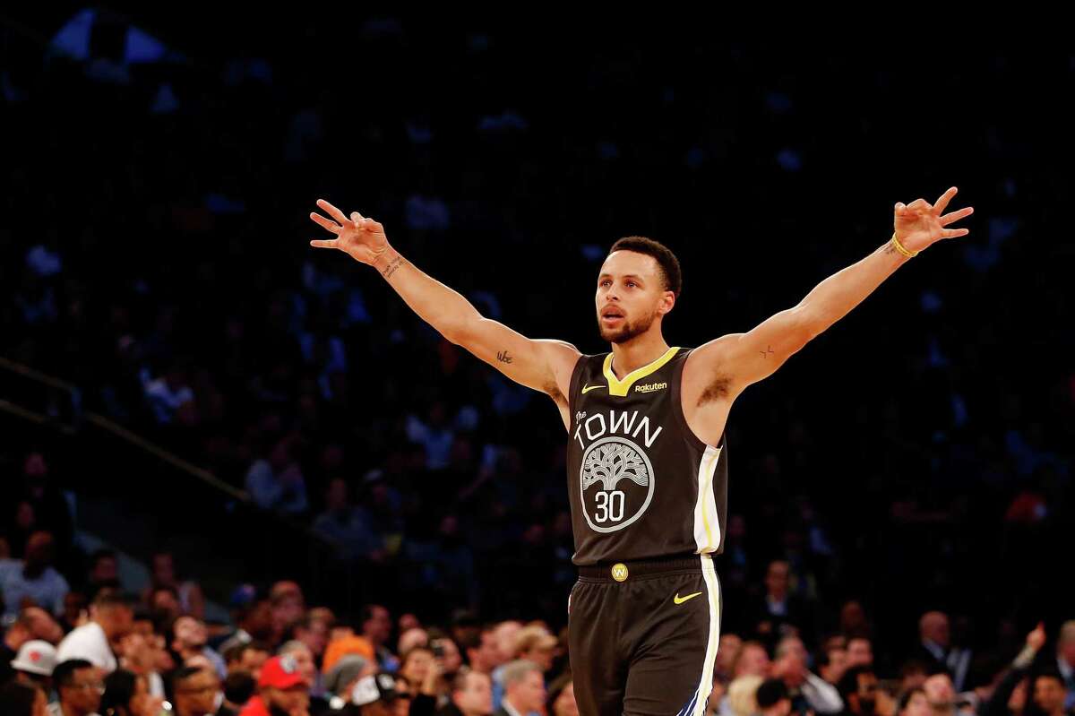 Stephen Curry #30 of the Golden State Warriors celebrates after teammate Alfonzo McKinnie #28 hits a three point basket against the New York Knicks during the fourth quarter at Madison Square Garden on October 26, 2018 in New York City.