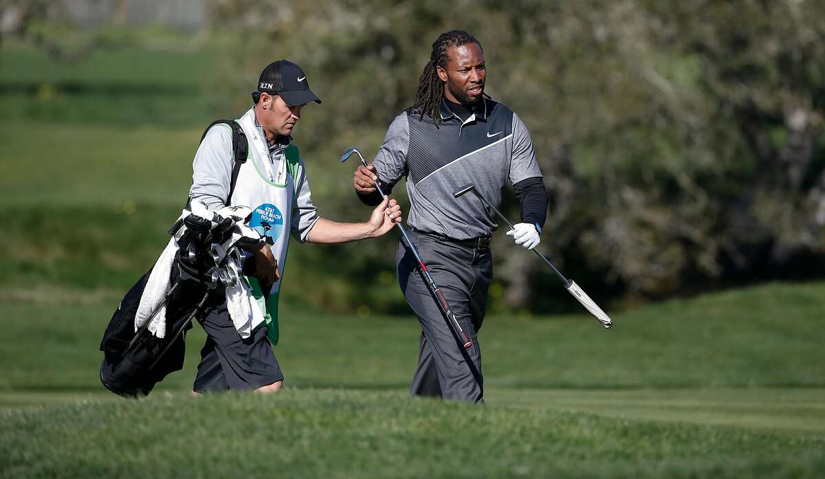Larry Fitzgerald, a wide receiver for the Arizona Cardinals grabs his putter from his caddie as he plays the 2nd hole at the Pebble Beach Golf Links, during the third round of the AT&T Pebble Beach Pro-Am on Sat. February 13, 2016, in Pebble Beach, California.