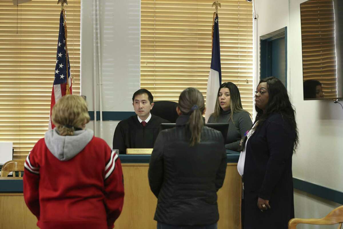 People accused of low-level misdemeanors appear before Travis County Justice of the Peace Precinct 5 Judge Nicholas Chu in Austin on Jan. 24, 2019. Police did not arrest them. Instead, under a cite and release program, they had been given a citation and told to appear in court within a month. With Chu are Court Clerk Maria Cristina Berrios, second from right, and Deputy Constable Kasben Harris, right. Berrios was interpreting for two Spanish-speaking defendants.