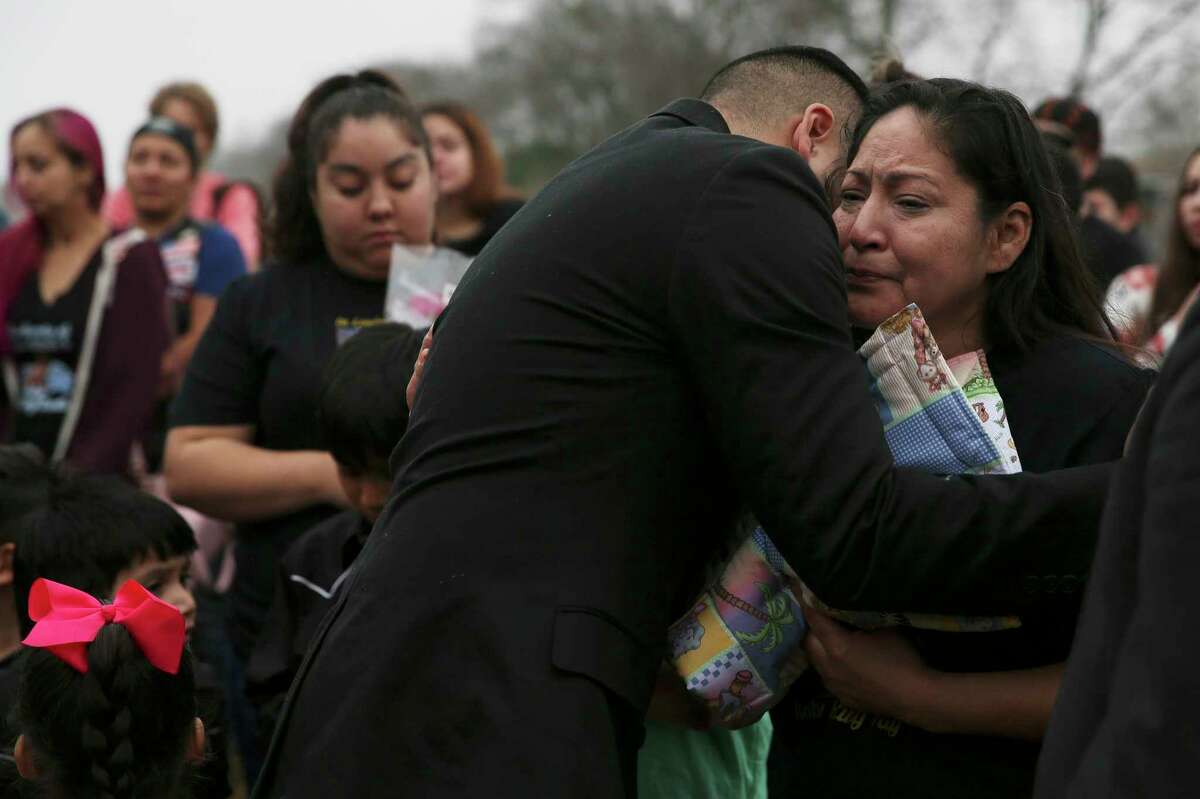 The maternal grandmother of baby King Jay Davila is hugged by Pastor Kenny Vallespin after she received a memorial quilt during a ceremony for baby King Jay Davila on Saturday, Feb. 2, 2019. Family, supporters and friends who knew baby King Jay Davila gathered for a memorial service at Christian World Worship Center. The service was hosted by Pamela Allen and her advocacy group, Eagles Flight. After the service, a procession went to the site of where the baby's father, Chris Davila, had buried the 8-month-old child on the city's Northeast side. At the site, a prayer service was held and doves were released by the child's maternal grandmother. Mourners were given packets of seed to spread in the field. At the conclusion, one of the white doves which were released stayed steadfast at the site as the small crowd slowly left the service.