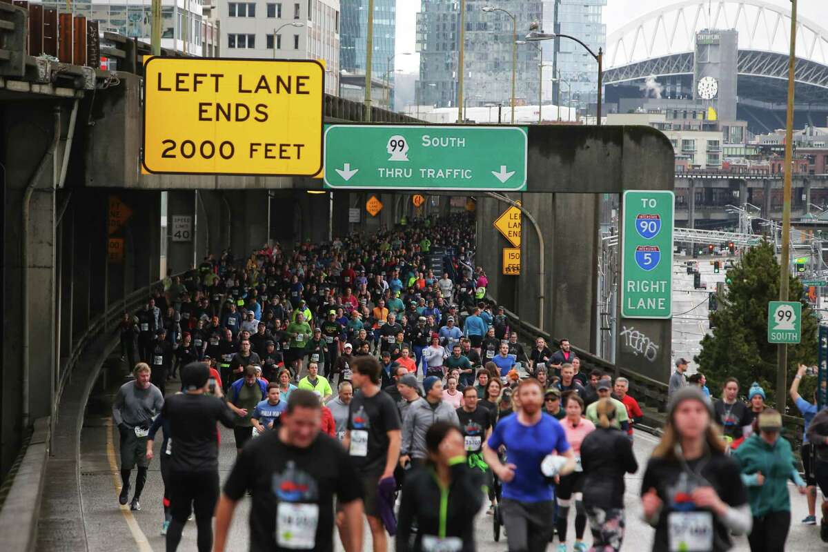 Twenty-nine thousand people participate in the Tunnel to Viaduct 8k, which allowed runners and walkers to travel south through the new SR 99 tunnel and north over the lower deck of the Alaskan Way Viaduct, Saturday, Feb. 2, 2019. Many runners stopped to take photos along the route, capturing what would be their last chance to walk along the viaduct before it is demolished later this month. The 8K is part of a weekend-long celebration marking the opening of the new tunnel, which 100,000 people were expected to attend. (Genna Martin, SeattlePI)
