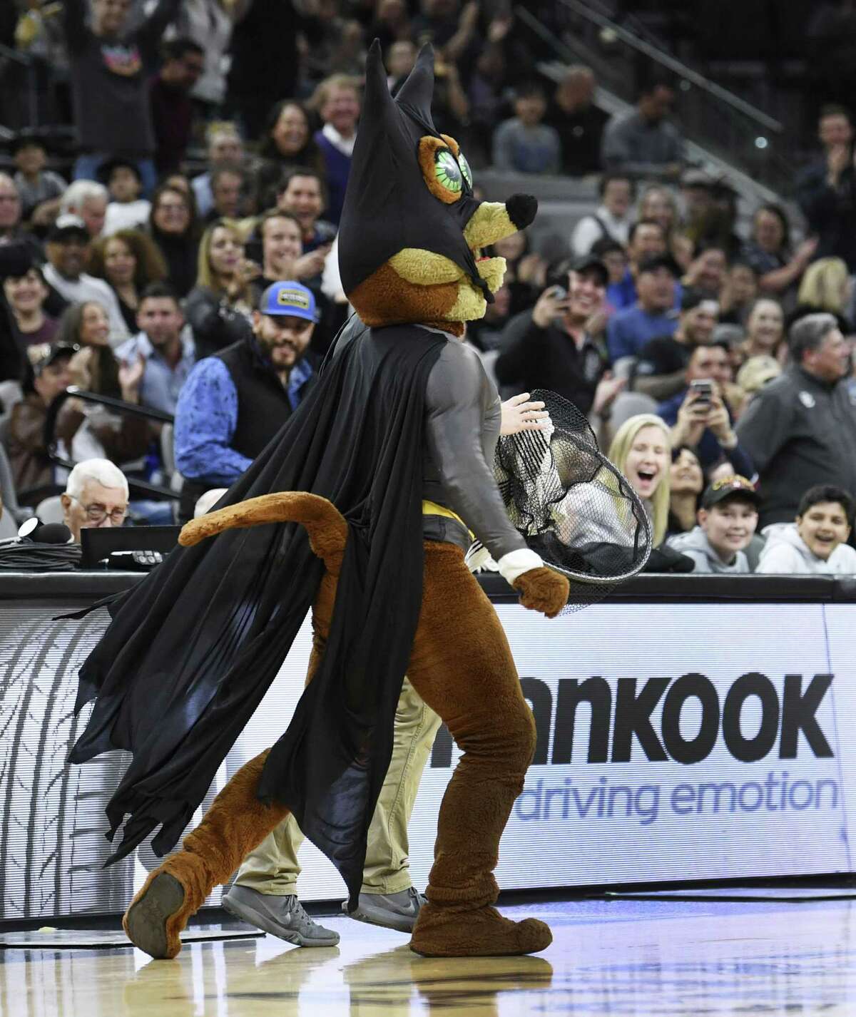 The Spurs Coyote and an assistant walk off the court with a bat that they caught during NBA action in the AT&T Center on Saturday, Feb. 2, 2019. The flying mammals have taken up residence in the arena.