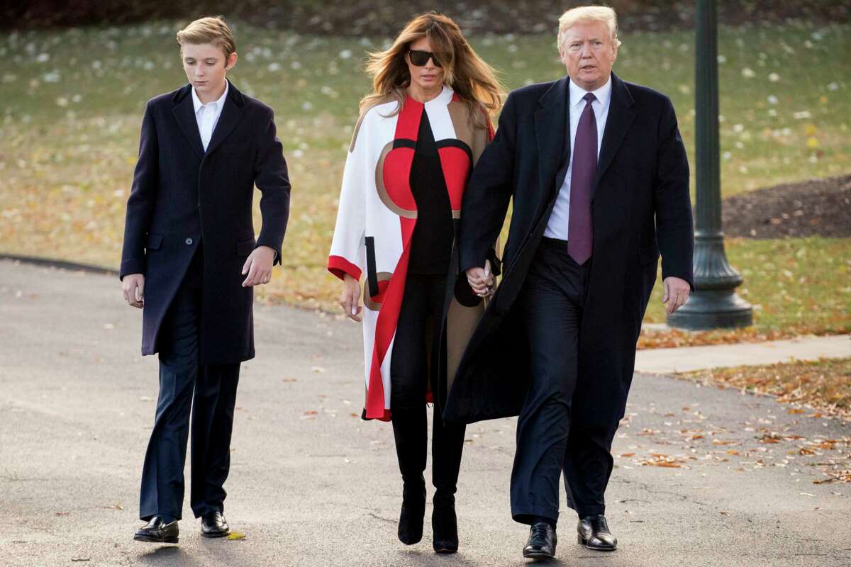 In this Nov. 20, 2018, file photo President Donald Trump accompanied by first lady Melania Trump, and their son Barron, left, walks towards Marine One on the South Lawn of the White House in Washington.