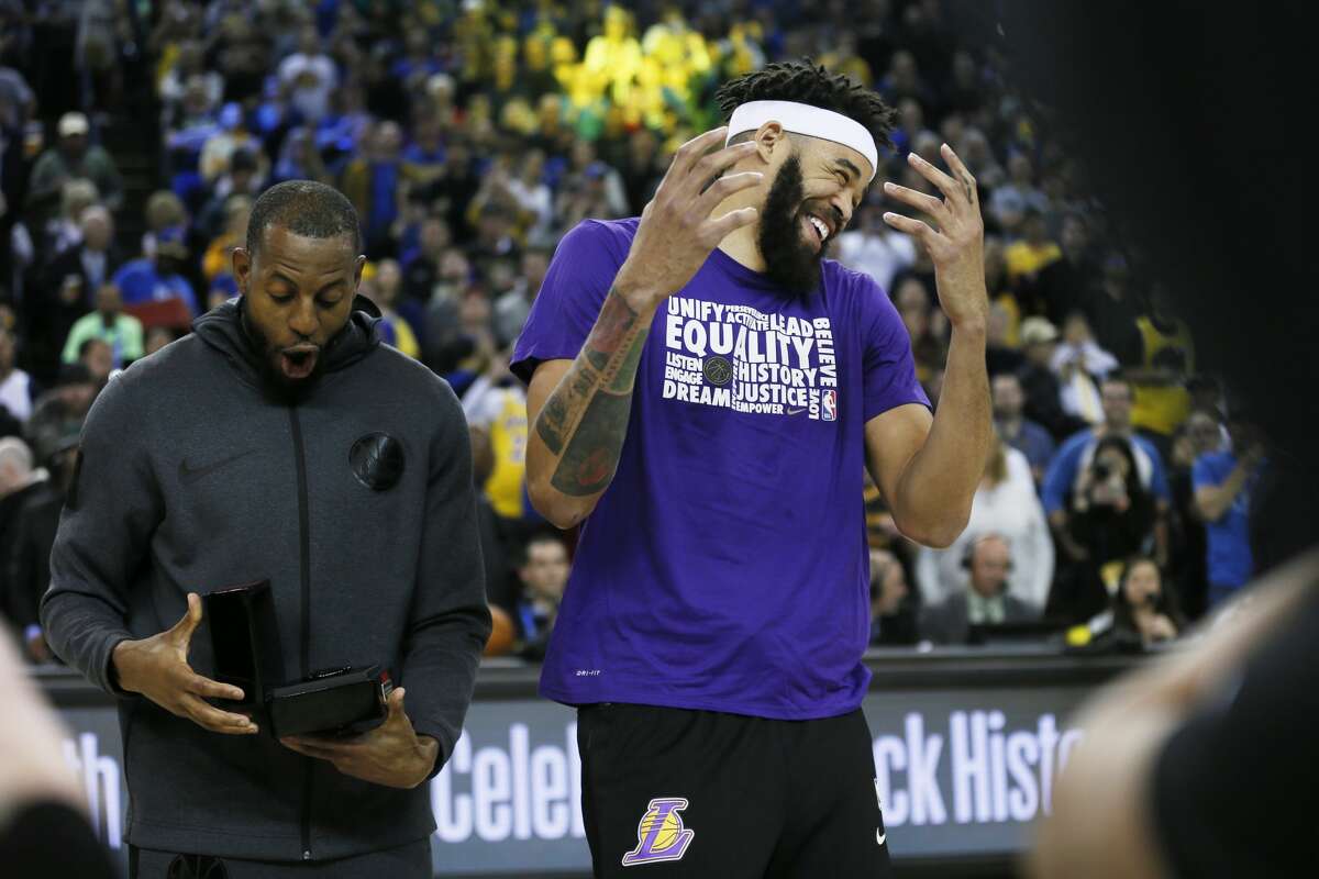 Golden State Warriors guard Andre Iguodala (9) hid the championship ring from former Warriors and now Los Angeles Lakers center JaVale McGee (7) before NBA game at Oracle Arena on Saturday, Feb. 2, 2019, in Oakland, Calif.