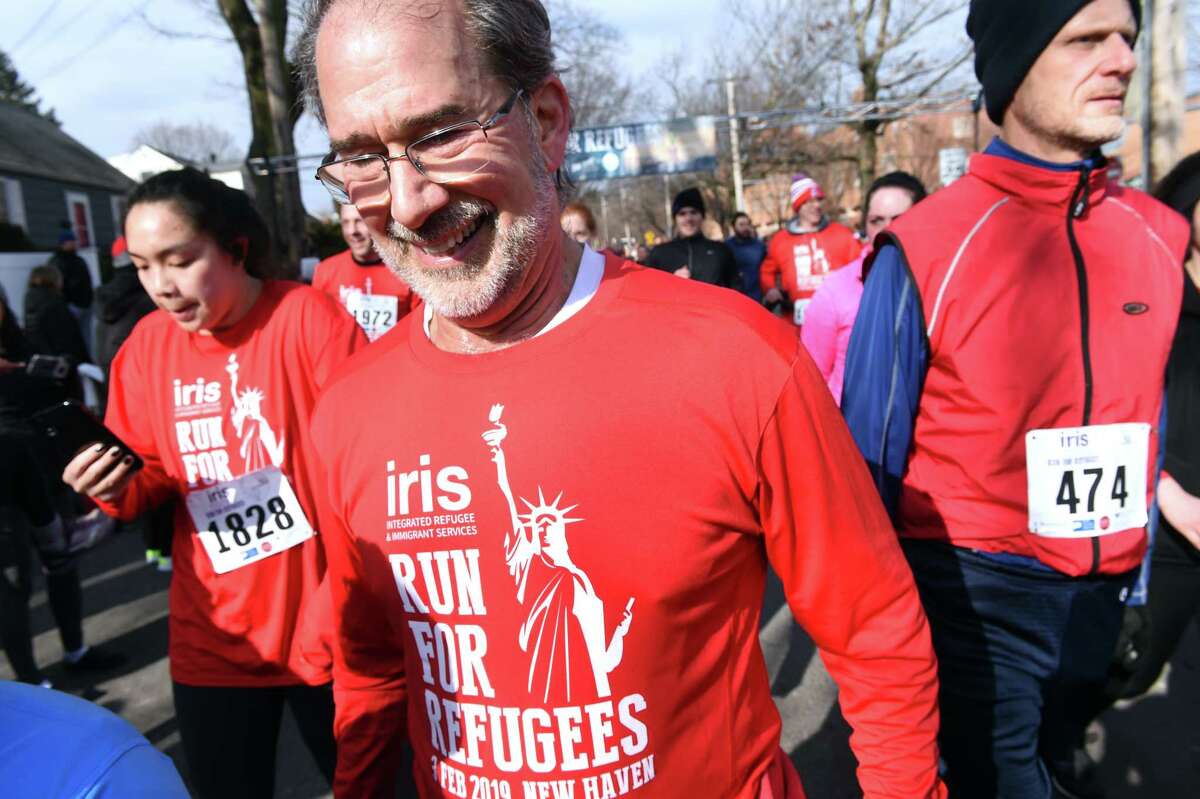 IRIS executive director Chris George (center) crosses the finish of the 12th Annual IRIS Run for Refugees 5K in New Haven on February 3, 2019.