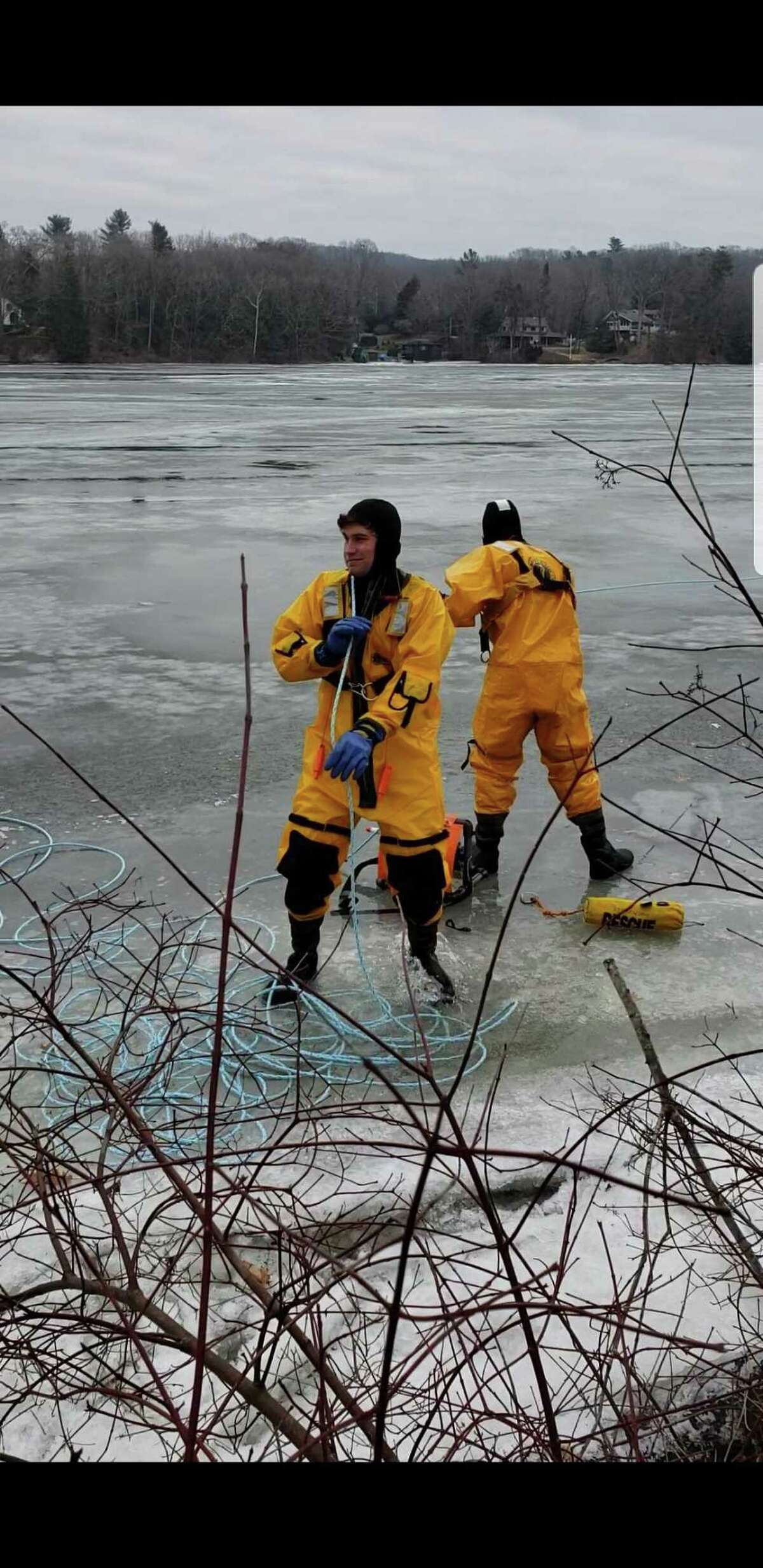 Firefighters Brock Butkovsky (left) and Chris Moquin (right) help rescue a deer that became stranded on the ice on Lake Zoar on Feb. 3, 2019.