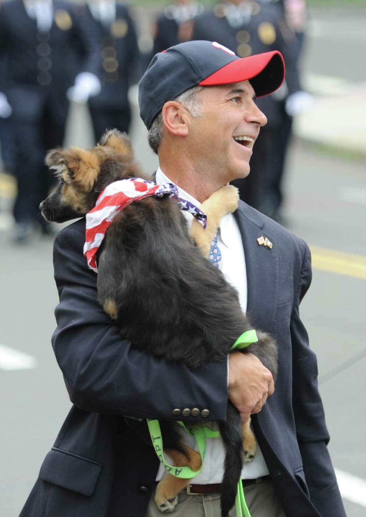 State Rep. Fred Camillo and his dog, Reagan, march in the Ninth District Veterans Association and the Glenville Volunteer Fire Company's annual Glenville Parade and Memorial Service in Greenwich, Conn. Sunday, May 27, 2018. Camillo will be sworn in as the new first selectman on Dec. 1.