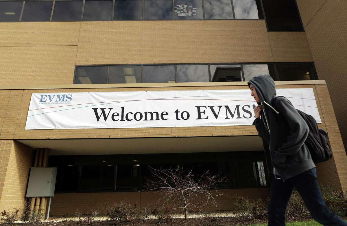 A pedestrian walks past a banner welcoming students and visitors to Eastern Virginia Medical School in Norfolk, Va., on Feb. 4.