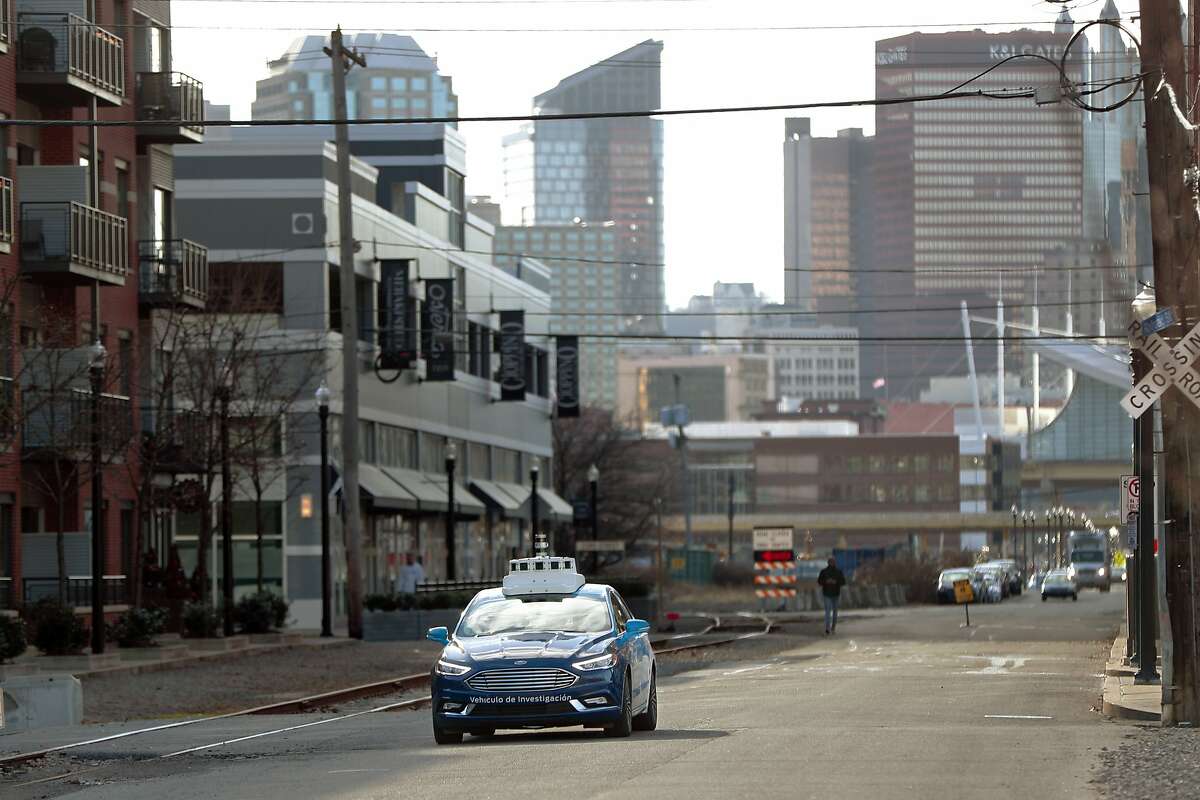 In this Dec. 18, 2018, photo one of the test vehicles from Argo AI, Ford's autonomous vehicle unit, navigates through the strip district near the company offices in Pittsburgh. Even the most optimistic experts say it will be 10 years before self-driving vehicles are everywhere, but others believe it will take decades. The biggest reasons are camera and laser sensors that can’t see through heavy snow or figure out where to go if lane lines are covered. (AP Photo/Keith Srakocic)
