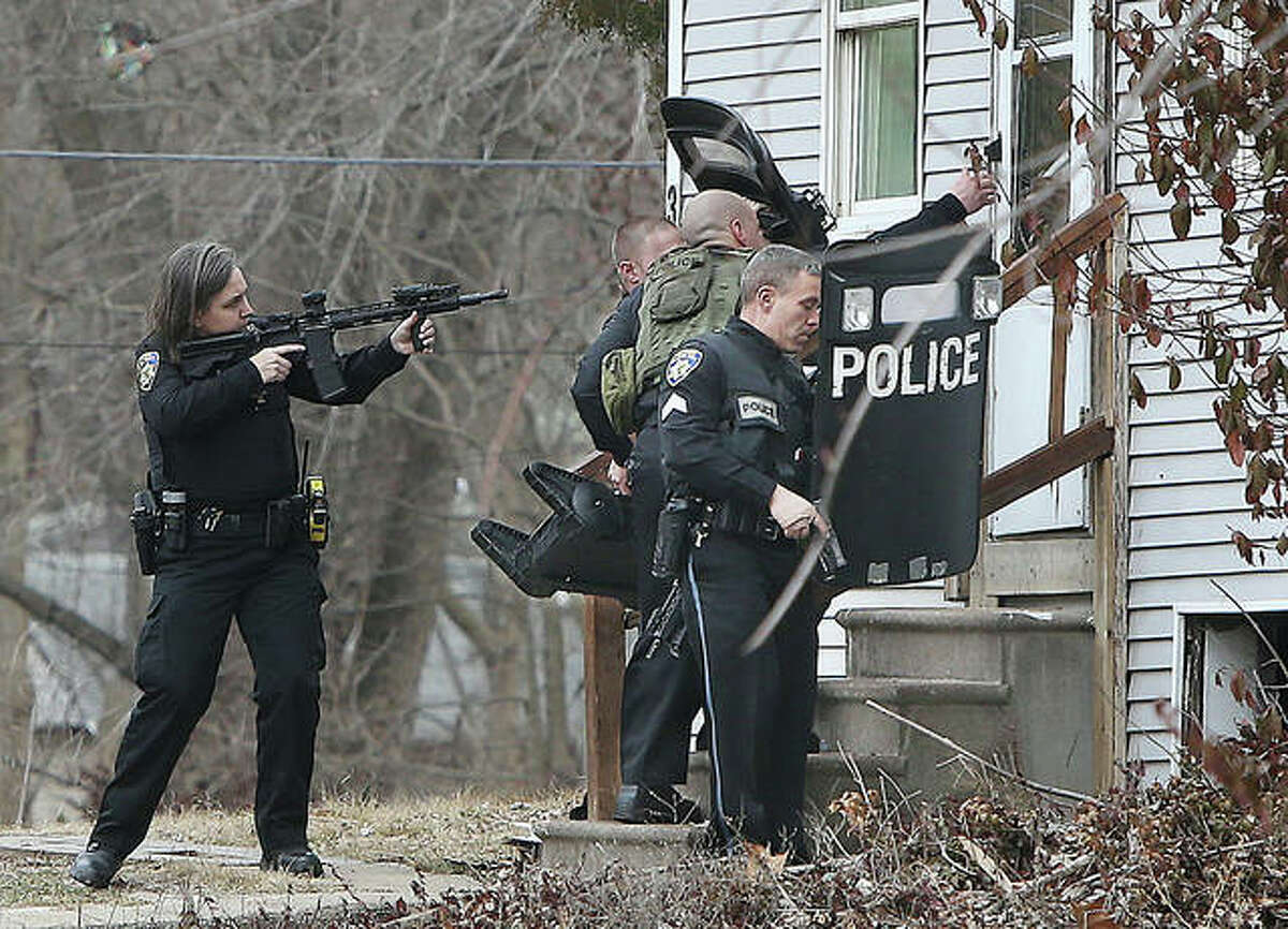 Alton police officers open the front door of a house in the 3000 block of Glenwood Avenue Monday to deploy a robot to search for a man believed to be in the house and armed with a gun. The standoff lasted more than an hour. While the camera was searching the inside of the house, the allegedly armed subject fled from a nearby hiding spot. After a foot chase involving more than a dozen officers and detectives, the man was taken into custody in the 2900 block of Edgewood Avenue.