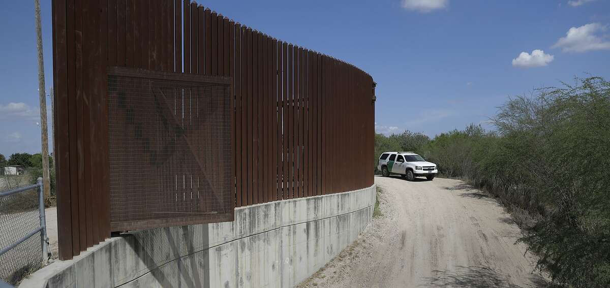 A U.S. Customs and Border Patrol vehicle passes along a section of border levee wall in Hidalgo, Texas in 2017. On Friday, A U.S. Border Patrol agent shot a man attempting to cross the border.