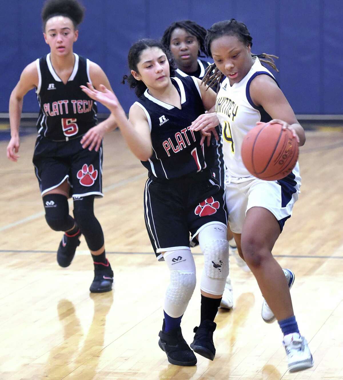Platt Tech's Angie Tocci, center, pressures Whitney Tech's Gianni Atkinson on Monday in Hamden.