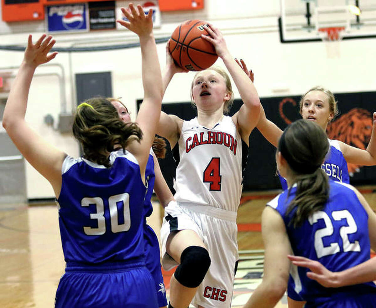 Calhoun’s Colleen Schumann (4) puts up a shot in the lane between Brussels’ Alyssa Kress and Toni Odelehr (22) on Monday night in a quarterfinal game at the Greenfield Class 1A Regional.