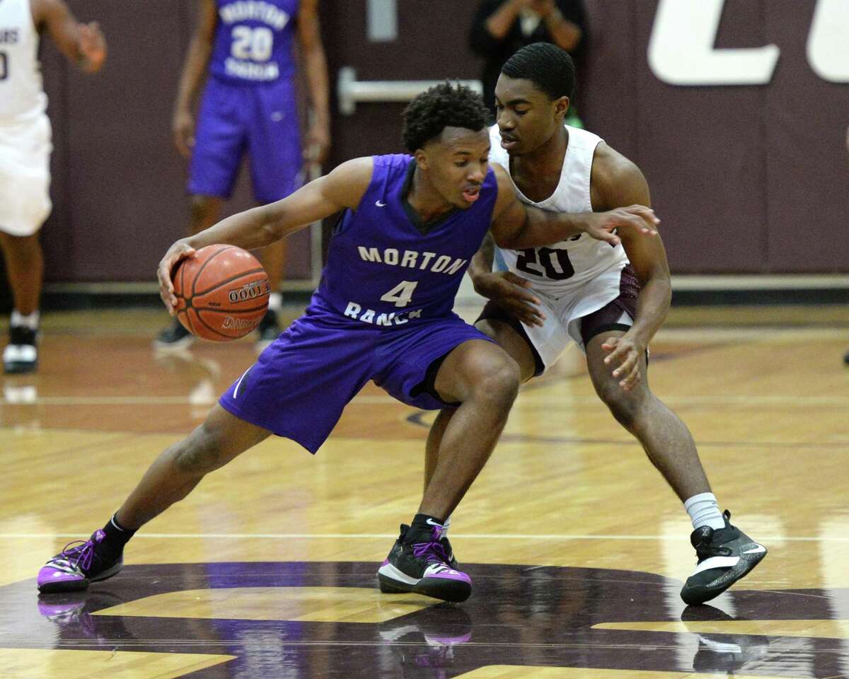 LJ Cryer (4) of Morton Ranch is guarded by Chris Ngene (20) of Cinco Ranch during the second half of a high school basketball game between the Cinco Ranch Cougars and the Morton Ranch Mavericks on Jan. 29 at Cinco Ranch HS in Katy.