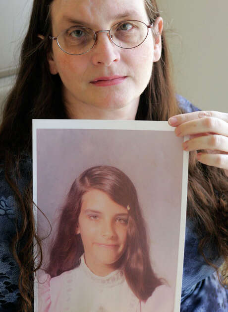 In this 2007 file photo, Debbie Vasquez holds a photo of herself at age 14, when she says she was first molested by the pastor of her church in Sanger, about one hour north of Dallas. (Donna McWilliam/Associated Press)