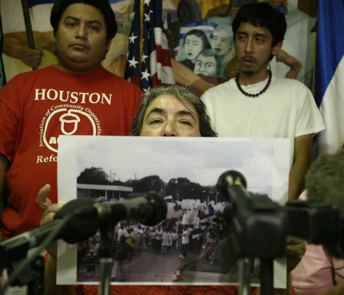 Maria Jimenez holds up a photo of a previous protest to demonstrate the number of people that CRECEN could get together to combat the Minutemen as she speaks during a press conference put together by CRECEN (Centro de Recursos Centroamericanos, Friday afternoon, July 8, 2005, to talk about their plans to deal with the Minutemen, who plan on photographing and video taping immigrants who hang out waiting for work on the street corners in Houston. (Karen Warren/Houston Chronicle) HOUCHRON CAPTION (07/09/2005) SECNEWS: TURNING OUT: Maria Jimenez on Friday holds up a photo of a previous protest to demonstrate the crowd that the Central American Resource Center could draw to counteract the Minutemen. "For every Minuteman patrolling, we will have at least 10 people patrolling them," she said.