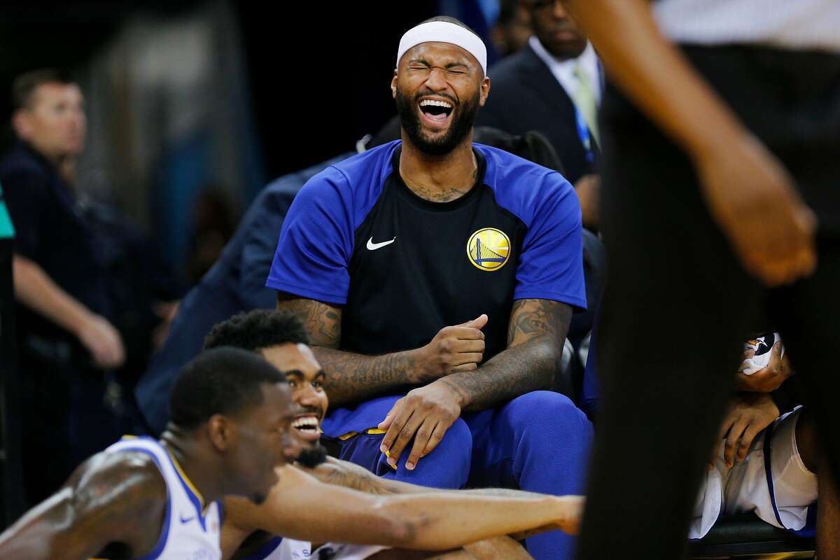 Golden State Warriors center DeMarcus Cousins (0) has a laugh with his teammates on the bench during the second half of an NBA preseason game between the Golden State Warriors and Minnesota Timberwolves at Oracle Arena on Saturday, Sept. 29, 2018, in Oakland, Calif. The Minnesota Timberwolves won 114-110.