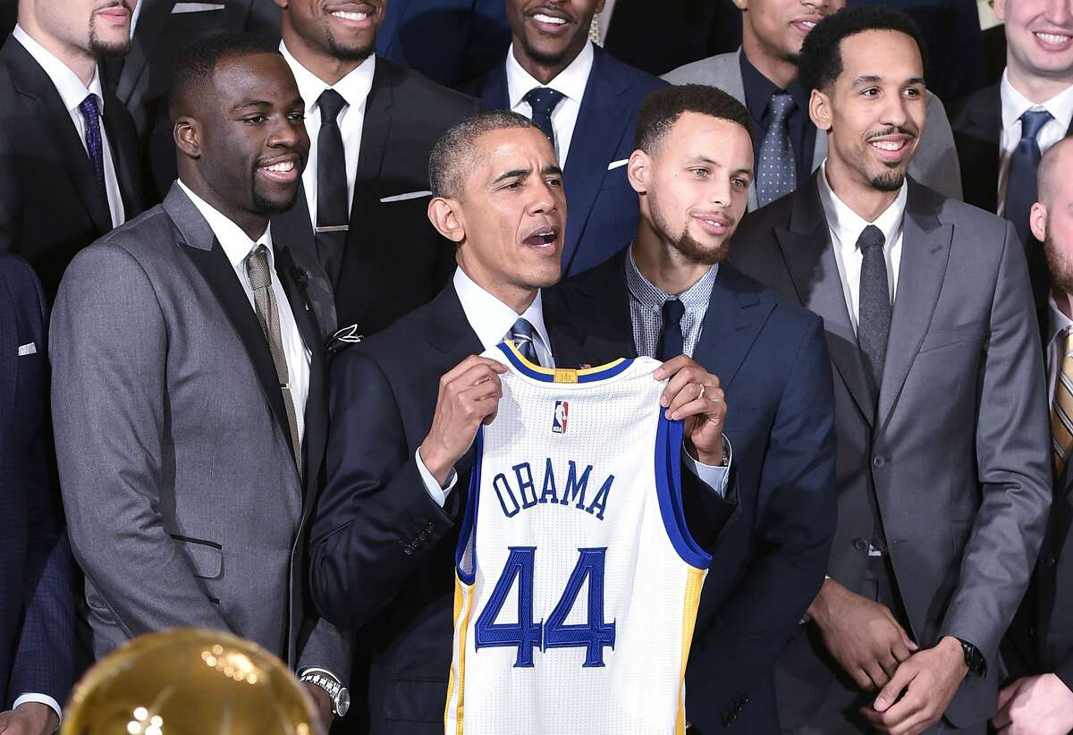 US President Barack Obama holds a jersey while poseing with forward Draymond Green (L), Golden State Warriors guard Stephen Curry (2nd R) and guard Shaun Livingston (R) during an event honoring the 2015 NBA Champion Golden State Warriors in the East Room of the White House on February 4, 2015 in Washington, DC. / AFP / MANDEL NGANMANDEL NGAN/AFP/Getty Images