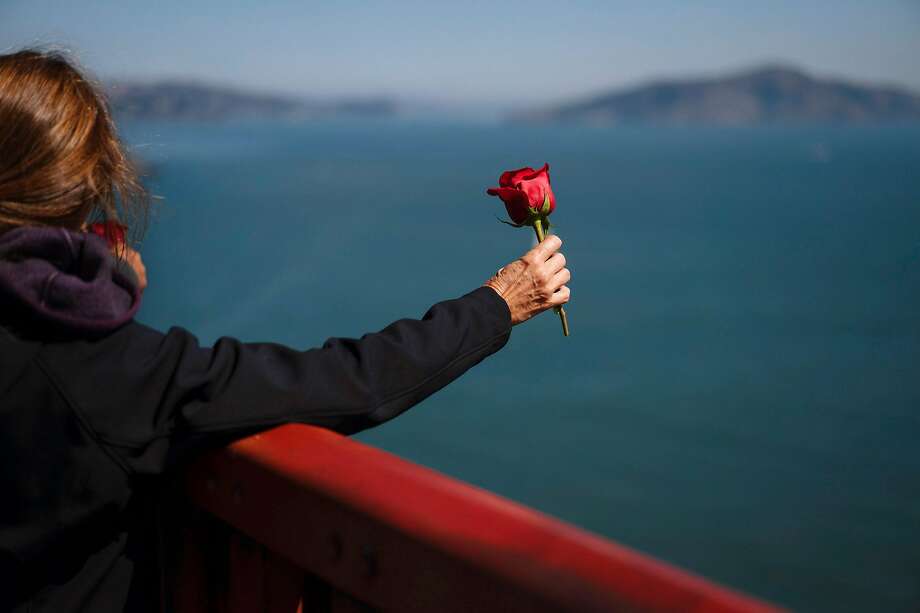 Kymberlyrenee Gamboa and her husband, Manuel Gamboa take a moment before tossing over a rose at the Golden Gate Bridge in San Francisco, Calif., on Thursday, Sept. 20, 2018. The Gamboa's waited to throw the rose till 11:45 a.m the moment that Kyle Gamboa had jumped off the bridge to his death. Photo: Mason Trinca / Special To The Chronicle