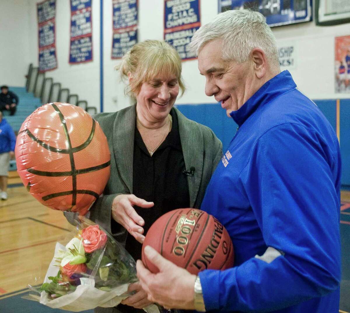 Danbury High School girls basketball coach Jackie DiNardo is presented the game ball by Athletic Director Chip Salvestrini after her 500th victory in a game against Bridgeport Central played at Danbury on Feb. 5.