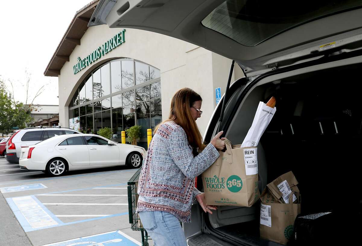 Debi LaBell loads groceries into her minivan at the Whole Foods Market in Redwood City, Calif., on Saturday, January 26, 2019. LaBell, an independent contractor, works for grocery delivery service Instacart on weekends for extra money. She is upset about a way Instacart has changed payments which she says results in lower wages.