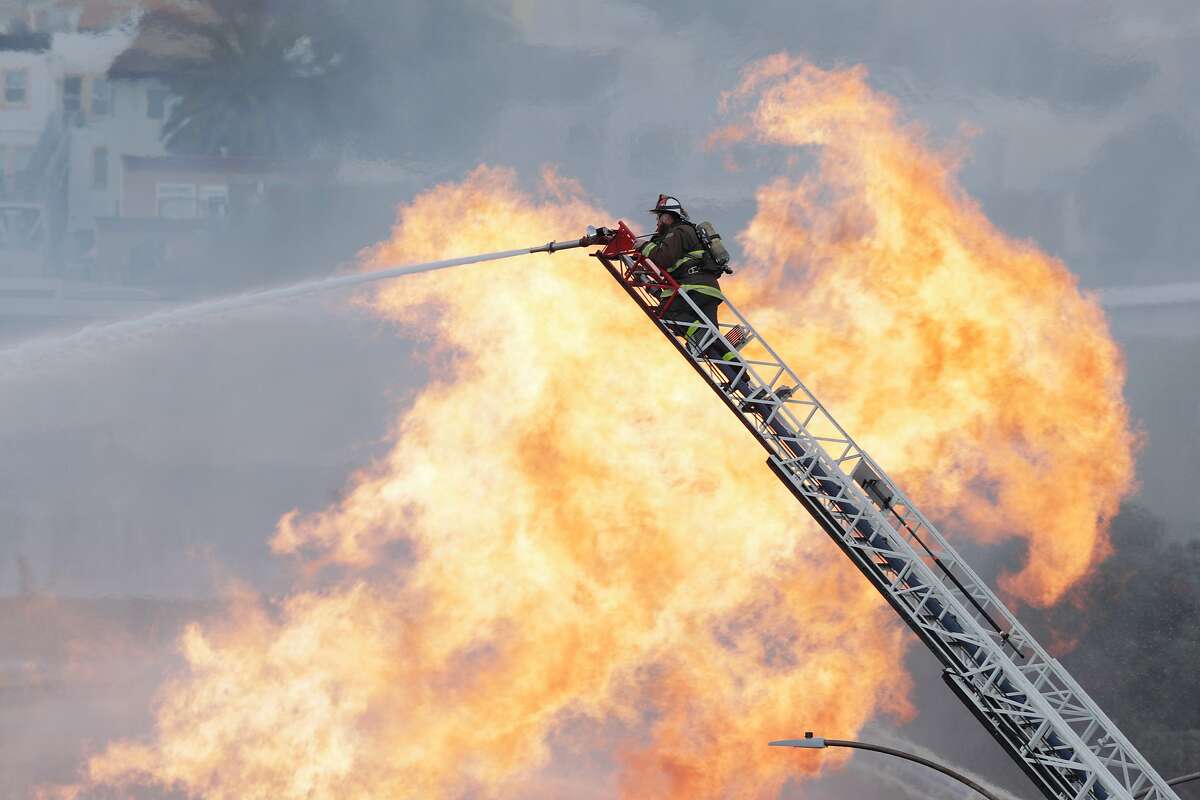 San Francisco firefighters battle a fire triggered by an explosion when a backhoe operator struck a natural gas line on Geary Blvd. near Parker Avenue on Wednesday, February 6, 2019.