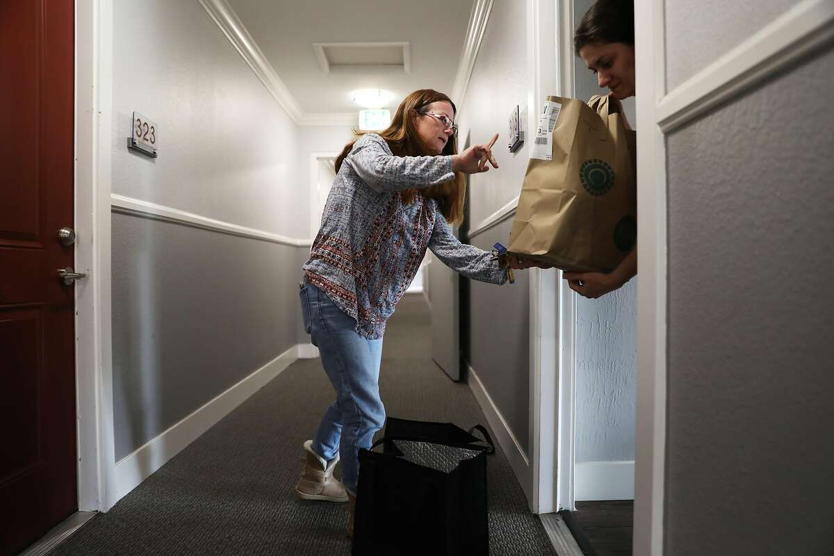 Debi LaBell delivers groceries to Marianna Ksovreli in Redwood City, Calif., on Saturday, January 26, 2019. LaBell, an independent contractor, works for grocery delivery service Instacart on weekends for extra money. She is upset about a way Instacart has changed payments which she says results in lower wages.