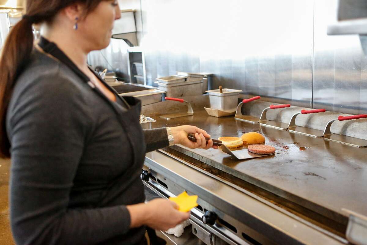 Gott's Culinary director, Jennifer Rebman, flips an Impossible burger pattie as it cooks at Gott's on Wednesday, February 6, 2019 in San Francisco, Calif.