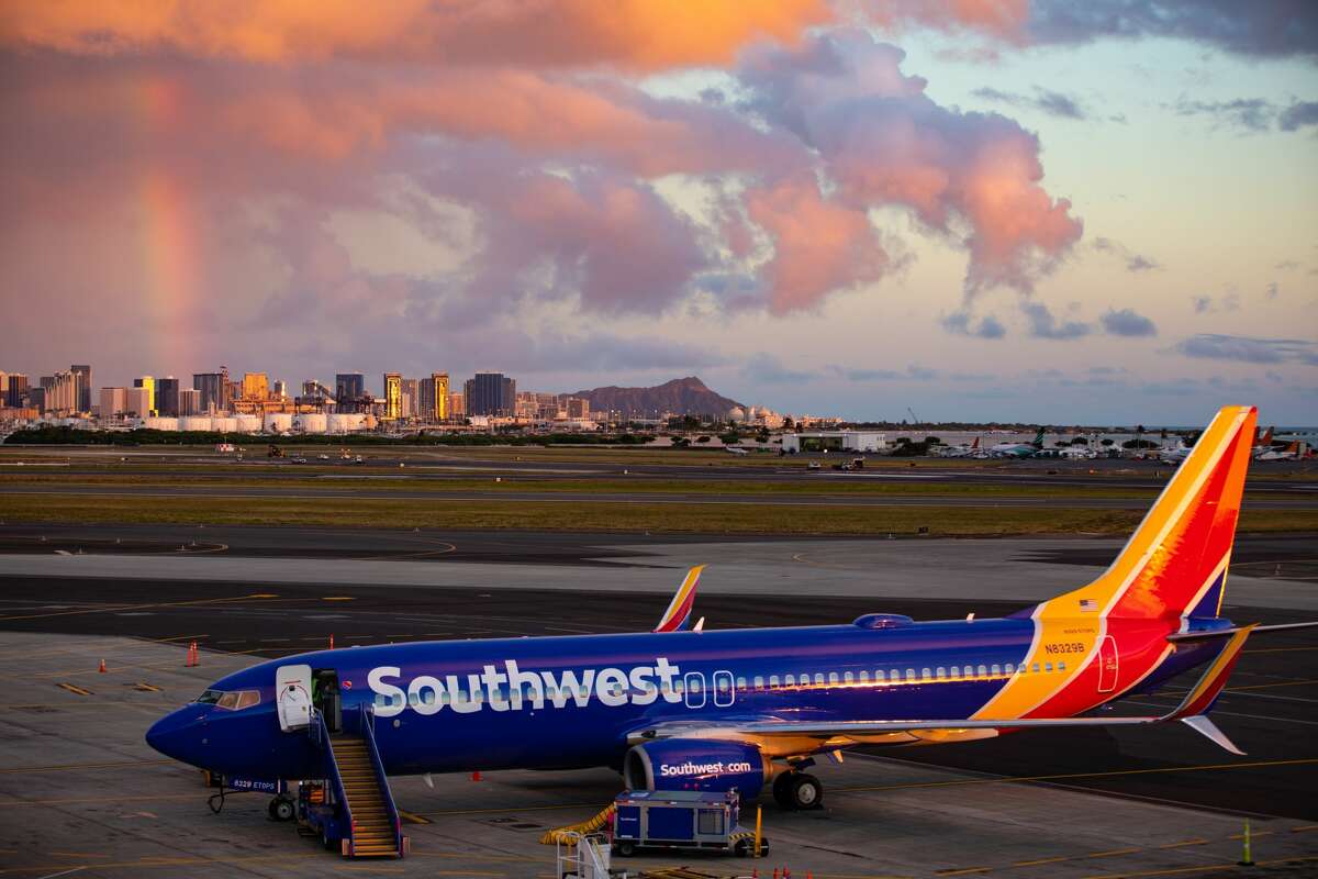 Southwest Airlines Boeing 737-800 at Daniel K. Inouye International Airport-- with Diamond Head and a rainbow in the backgroud