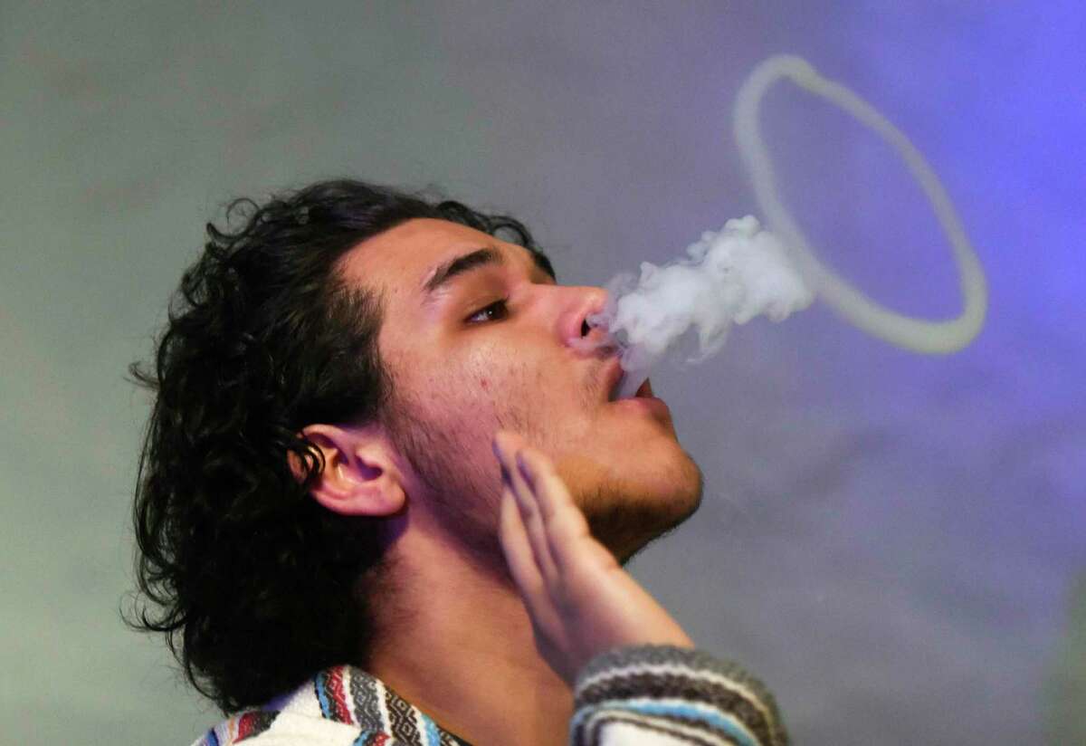 Angel Salcedo, of Port Chester, N.Y., blows a ring while vaping at CLOUDS Vapors & Lounge in the Byram section of Greenwich, Conn.
