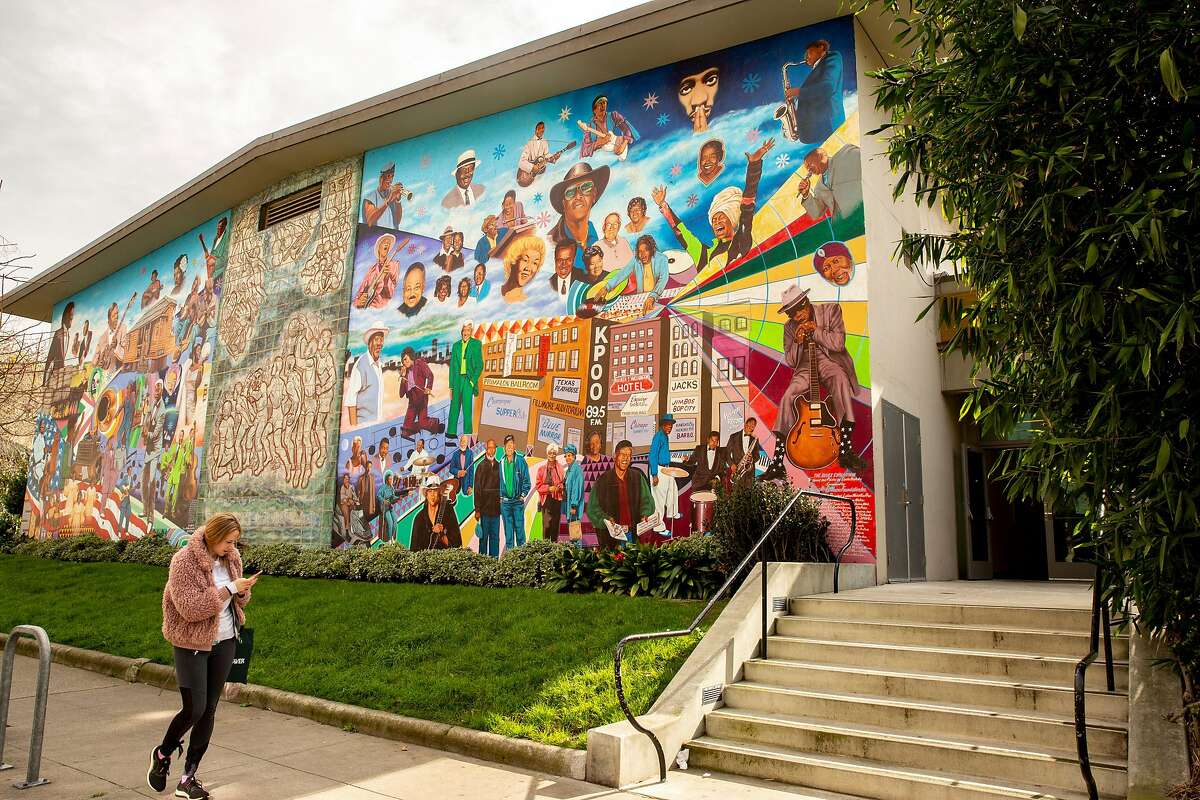 A woman walks past the Fillmore Blues Evolution mural at the Hamilton Recreation Center in the Western Addition neighborhood on Thursday, Feb. 7, 2019, in San Francisco, Calif.