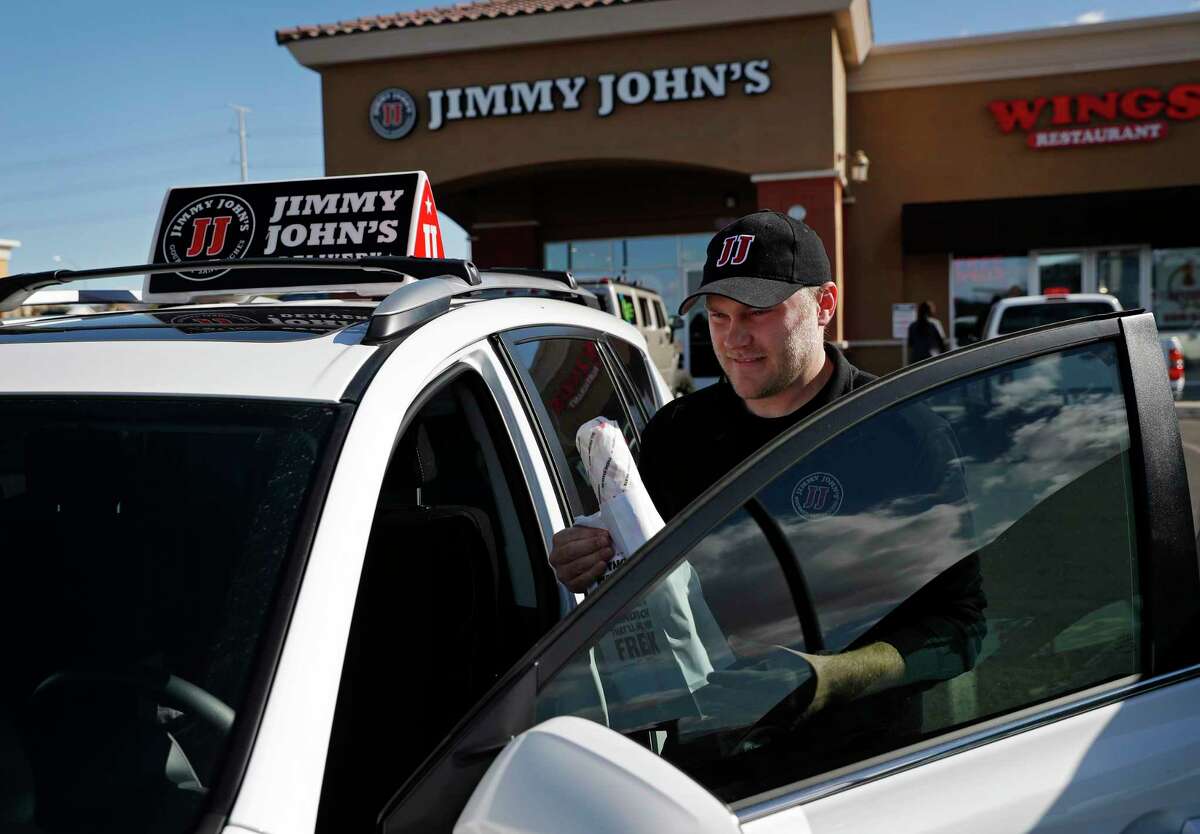 In this Wednesday, Feb. 6, 2019, photo, Tyler Schwecke, a delivery driver for Jimmy John's, gets in his car to make a delivery in Las Vegas. Food delivery services like Uber Eats and GrubHub are taking off like a rocket, but some restaurants aren't on board. This week, Jimmy John's sandwich chain launched a national ad campaign promising never to use third-party delivery. (AP Photo/John Locher)