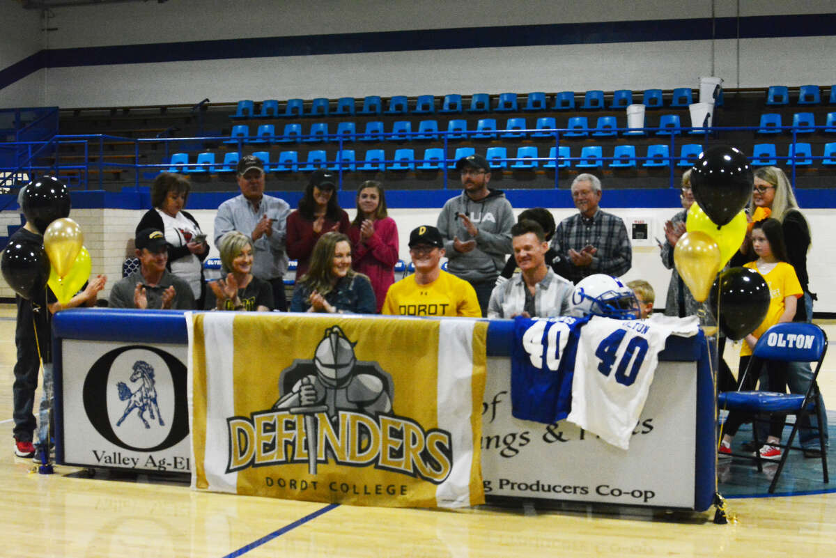 Olton senior running back Zane Gunter (yellow shirt) makes his collegiate future official by signing his National Letter of Intent to play football at Dordt College in Sioux City, Iowa, on National Signing Day Wednesday in Olton.