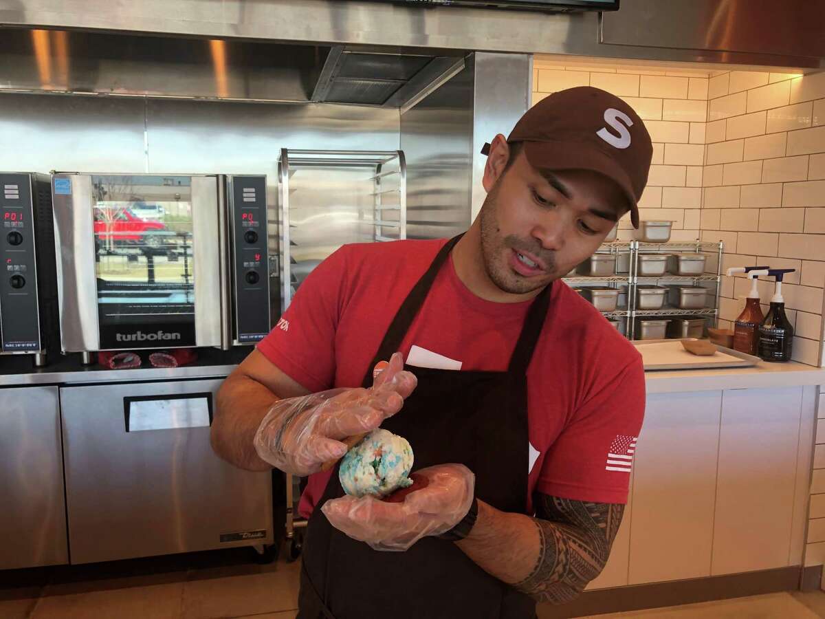 Owner Jay Reyes puts the finishing SMOOSH on an ice cream sandwich at his Heights storefront that opened last September. SMOOSH has nine types of cookies, 20 flavors of ice cream and 18 toppings.