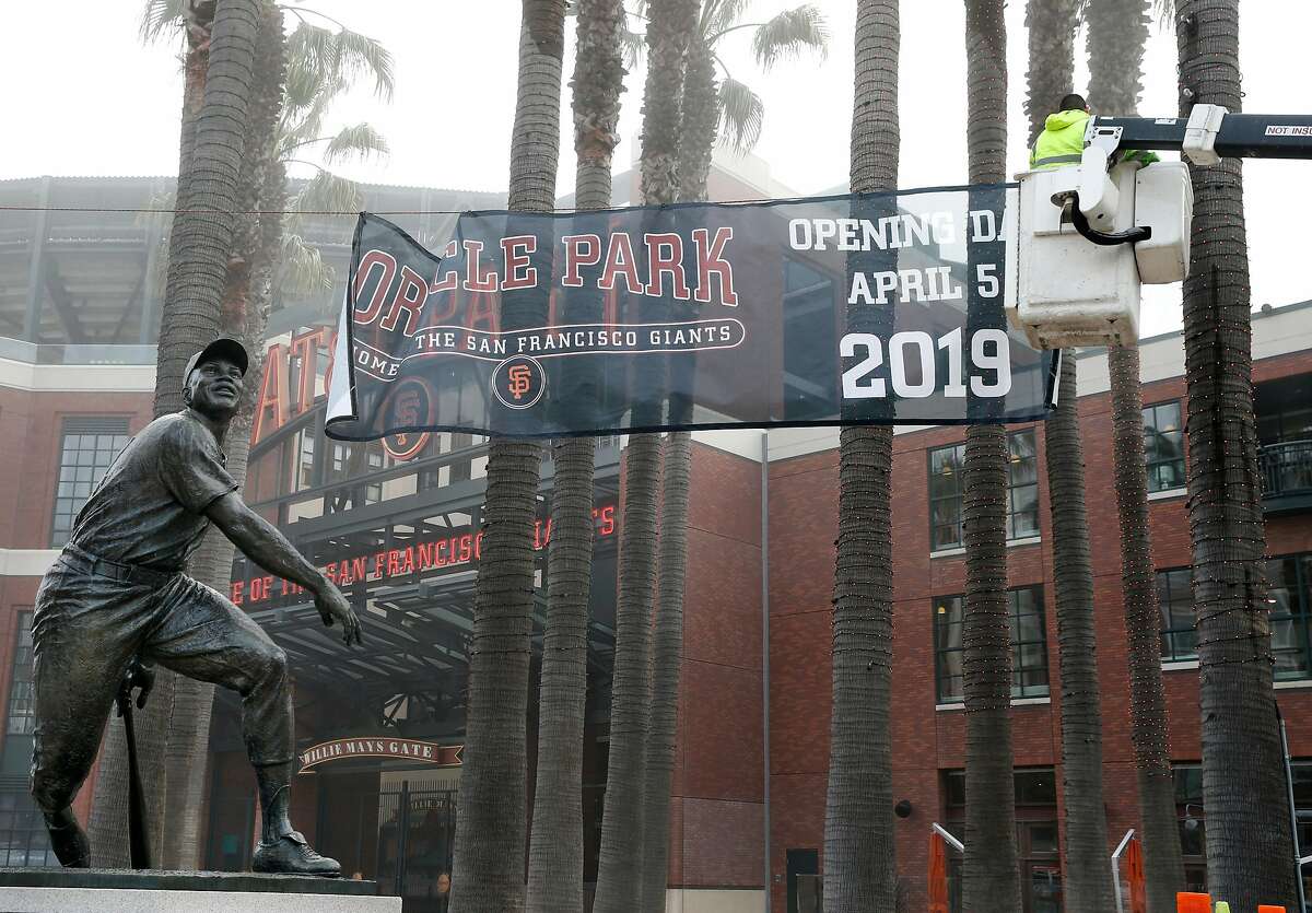 A crew from a sign company hangs a temporary banner in Willie Mays Plaza bearing the new name of the ballpark where the Giants play before the team announced that AT&T Park will be renamed Oracle Park in San Francisco, Calif. on Thursday, Jan. 10 2019.