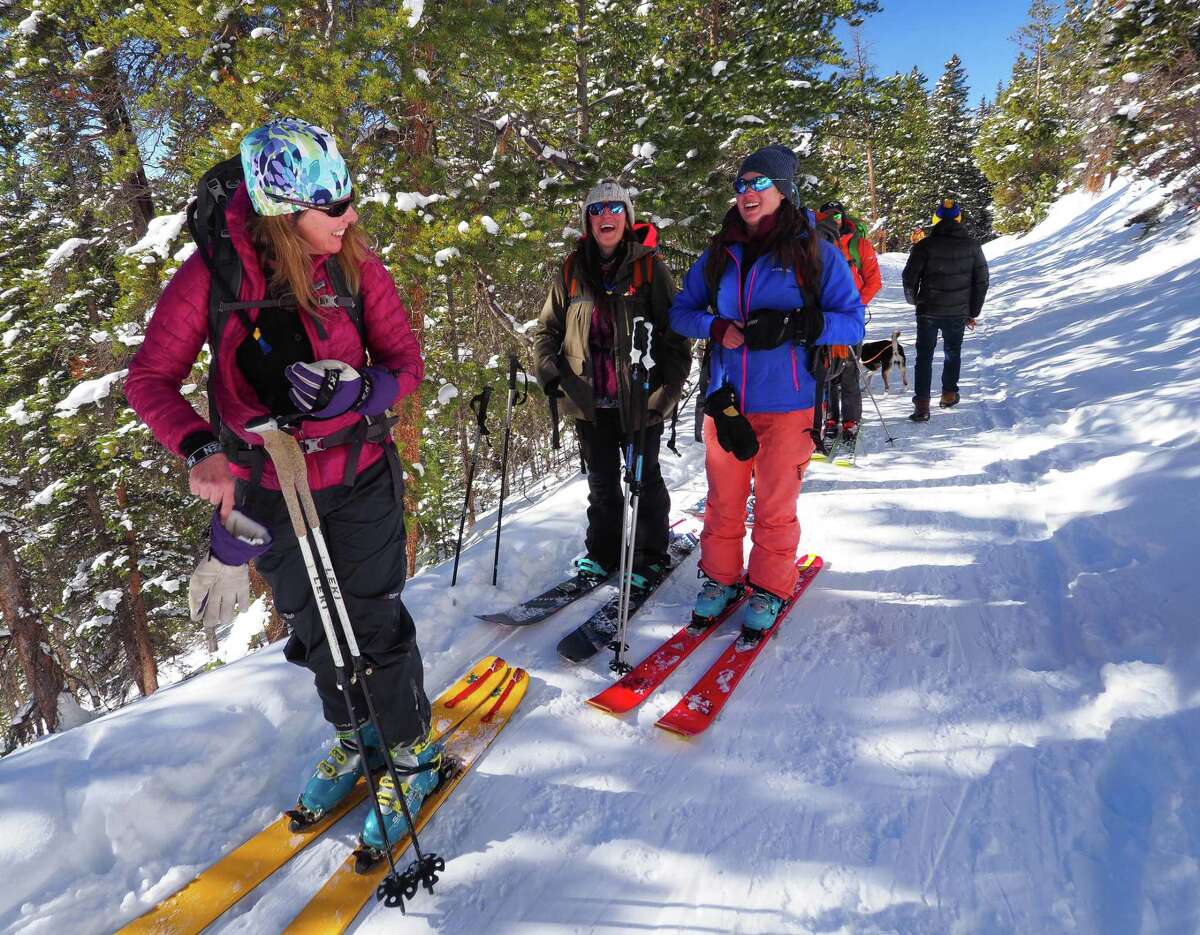 Cindy Herschfield, left, Sara Lococo, center, and Daliah Singer laugh as they skin toward Sisters Cabin east of Breckenridge.