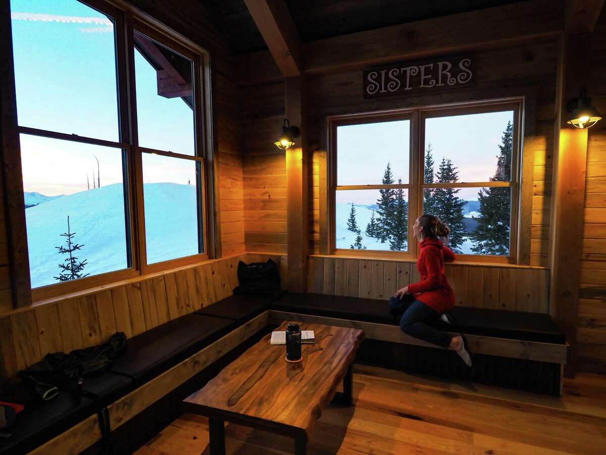 Austyn Dineen watches the sun set out the window at Sisters Cabin in Colorado.