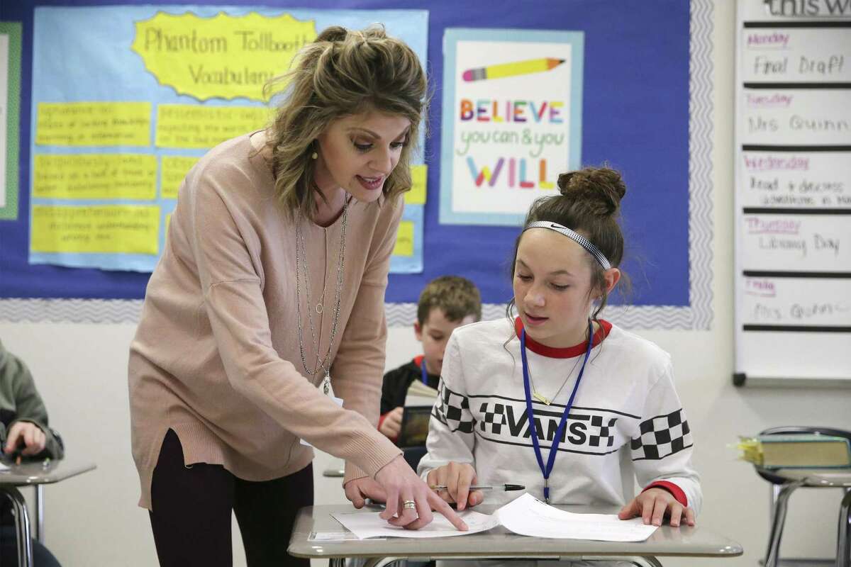 Stephanie Quinn, a New Braunfels Middle School sixth-grade teacher, works with student Halle Huber in class Friday. Teachers and local school districts are increasingly bearing the burden of soaring health care costs, while the state has kept its own contribution flat over the past 15 years.