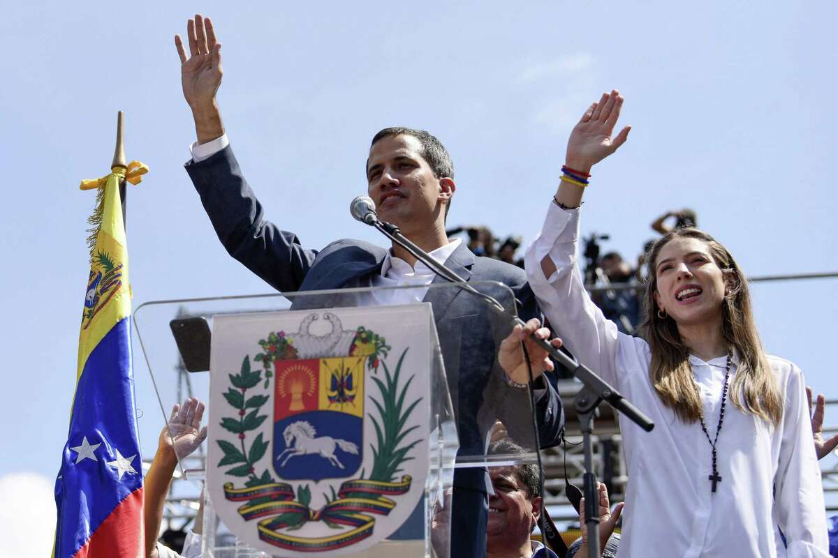 Juan Guaido, president of the National Assembly who swore himself in as the leader of Venezuela, and his wife, Fabiana Rosales, raise their hands during a pro-opposition protest in Caracas, Venezuela, on Feb. 2, 2019. MUST CREDIT: Bloomberg photo by Carlos Becerra