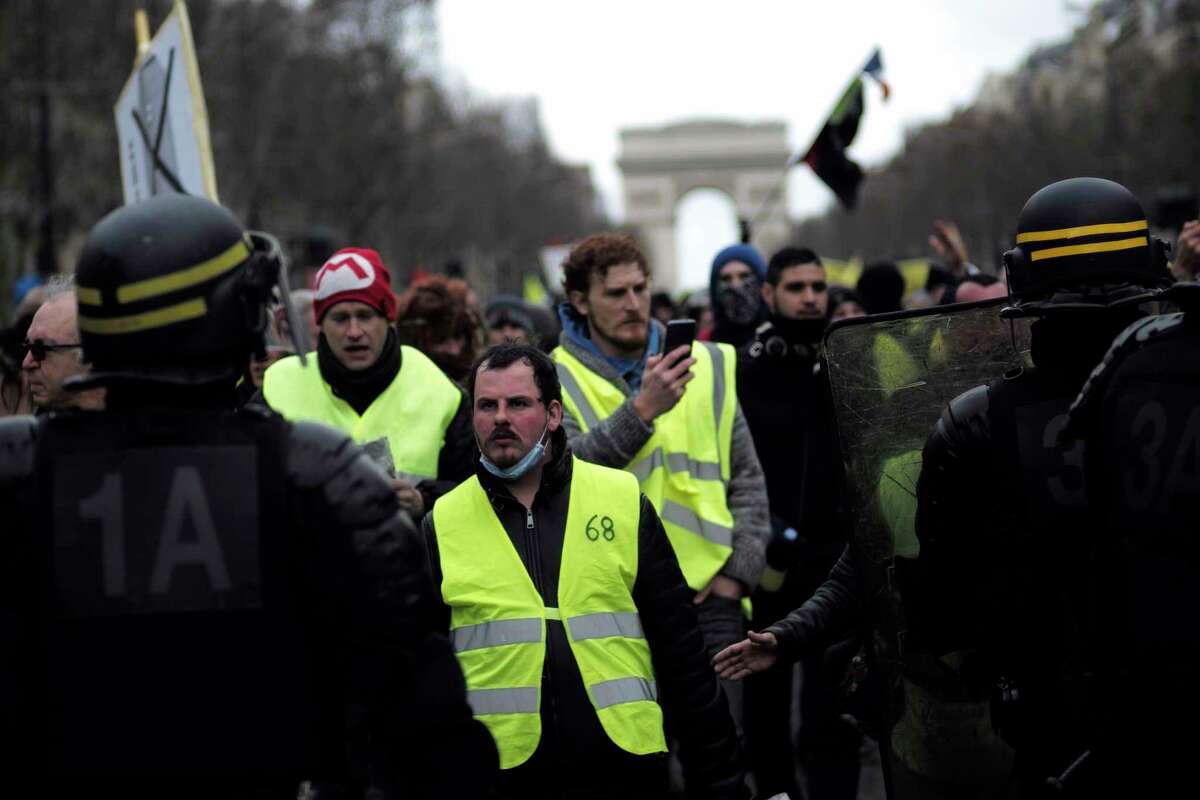 Yellow vest protesters walk down the famed Champs Elysees avenue to keep pressure on French President Emmanuel Macron's government, for the 13th straight weekend of demonstrations, in Paris, France, Saturday, Feb. 9, 2019. (AP Photo/Kamil Zihnioglu)