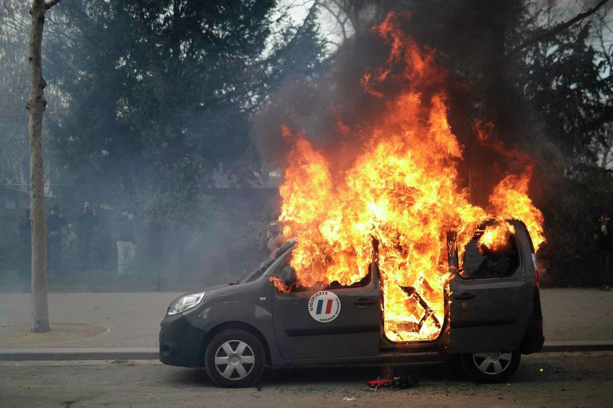A burning command car belonging to France's anti-terror 'Vigipirate' squad, dubbed 'Operation Sentinelle', is pictured during a demonstration as yellow vests protesters keep pressure on French President Emmanuel Macron's government, for the 13th straight weekend of demonstrations, in Paris, France, Saturday, Feb. 9, 2019. (AP Photo/Kamil Zihnioglu)