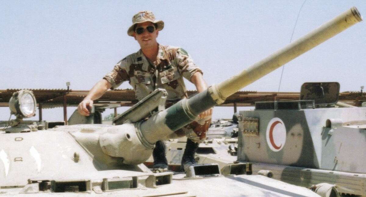 Army Capt. Norman Massry stands on top of a captured Iraq Army tank. (Army)