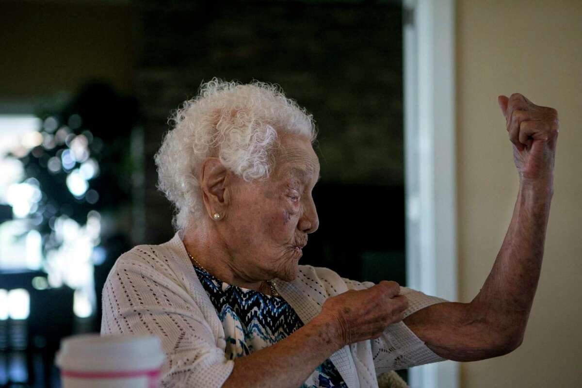 Ofelia Gonzales shows off her muscles during a monthly family gathering of three of her granddaughters at the Shenandoah Homes Community Guesthouse, Nov. 29, 2018. Gonzales outlived her husband and seven of her 10 children but still loved to joke with friends and family, dance and sing. She died Feb. 23 after breaking a leg in a fall in December. She was 109.