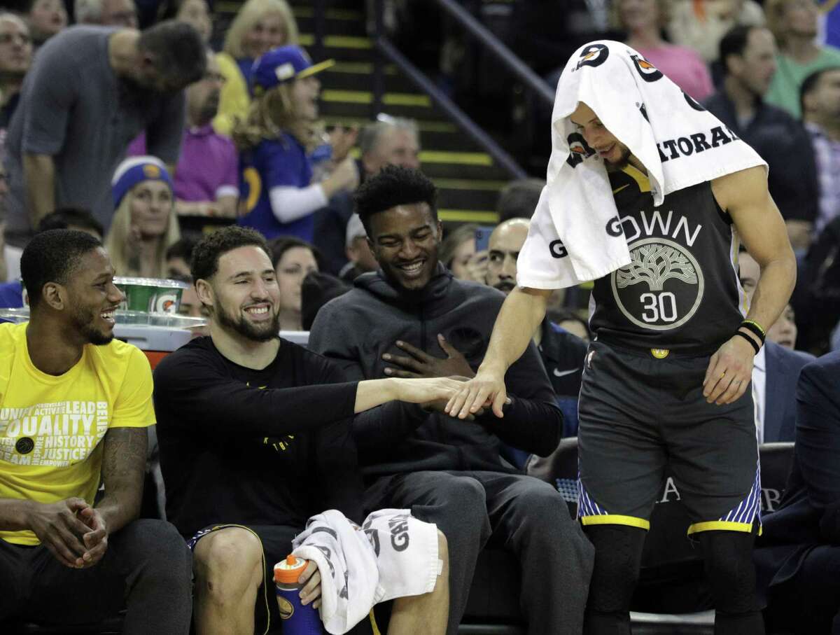 Klay Thompson (11) and Stephen Curry (30) high five after Jonas Jerebko (21) hit a three pointer in the first half as the Golden State Warriors played the Miami Heat at Oracle Arena in Oakland, Calif., on Sunday, February 10, 2019.