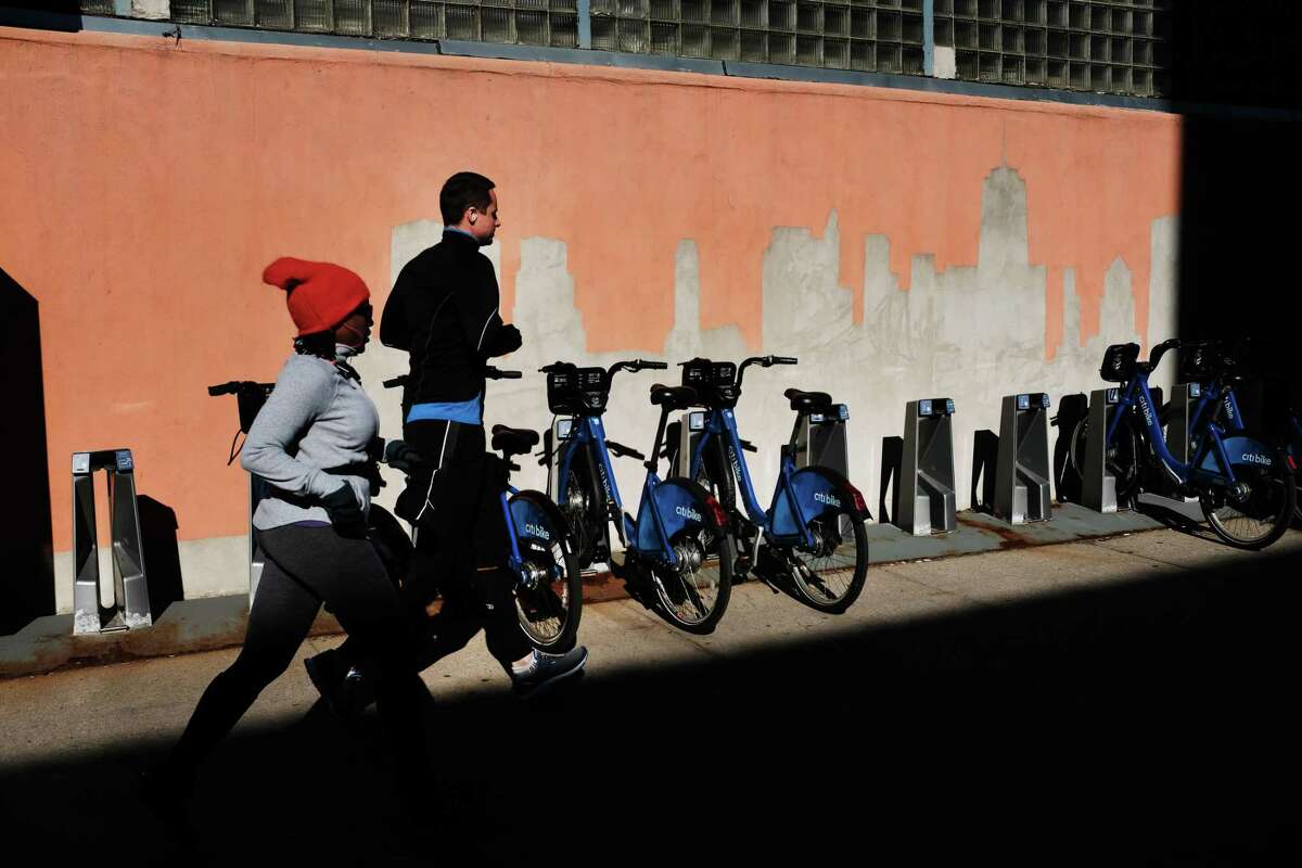 People run through the Long Island City neighborhood on Feb. 9, 2019, in Queens, N.Y. According to recent reports, Amazon is reconsidering its plan to locate one of its new headquarters in Long Island City due to the opposition the project has received locally.