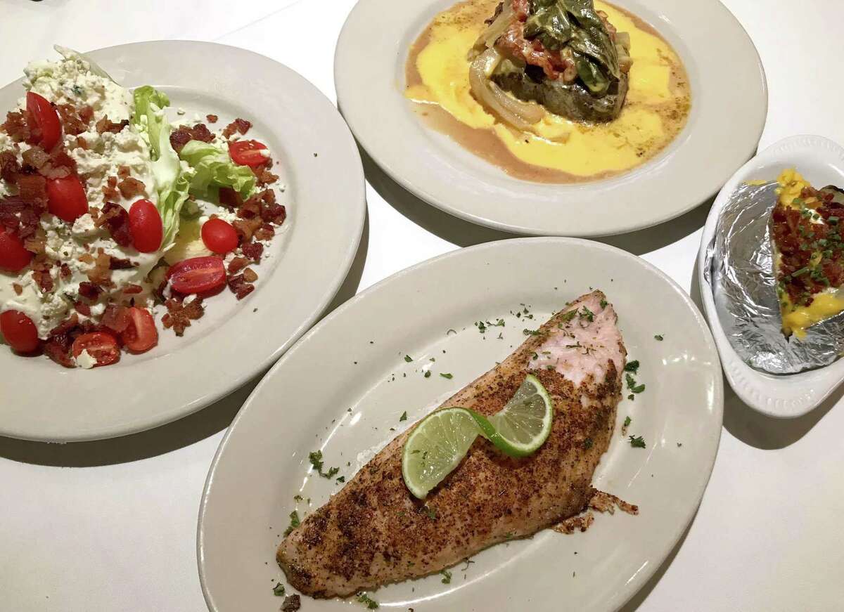 Wedge salad (clockwise from left), the House Special Steak, a loaded baked potato and grilled red snapper from Hoffman's Steakhouse